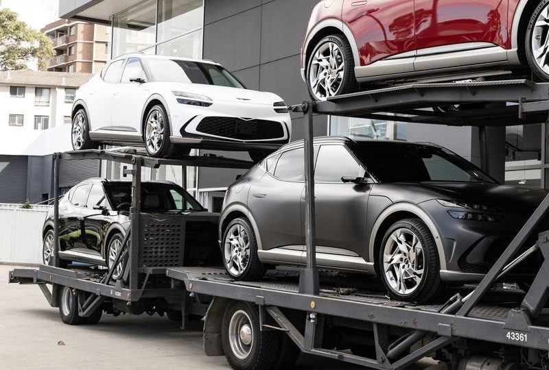 Автовоз з авто біля автосалону
